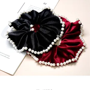 Close-up of velvet scrunchies in black and burgundy with elegant pearl edge detailing
