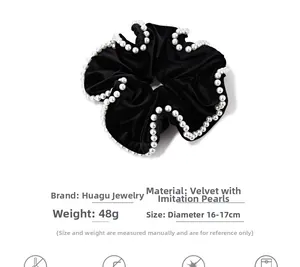 Detail view of large black velvet hair scrunchie with elegant pearl edge trim