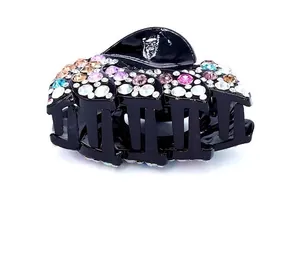 Detail view of a black acrylic hair claw clip with colorful sparkling rhinestones