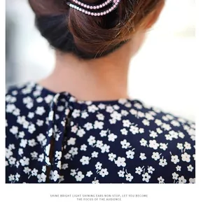 Close-up of elegant black hair claw clip with pink rhinestones on woman hair