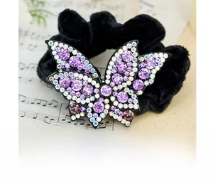 Dettaglio dell'elastico in velluto con ornamento a farfalla in strass viola