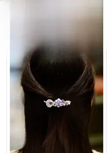 Détail d'une pince à cheveux fleur violette artisanale avec strass sur cheveux