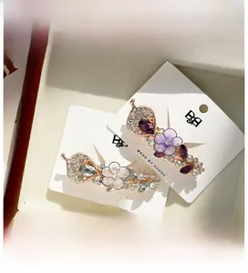Détail de barrettes à fleurs avec strass et cristaux présentées sur une carte