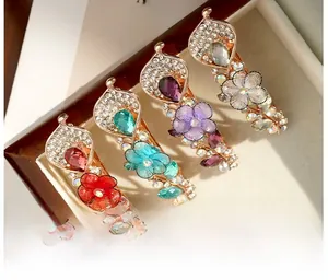 Gros plan de barrettes à fleurs en or rose ornées de strass en forme de goutte d'eau