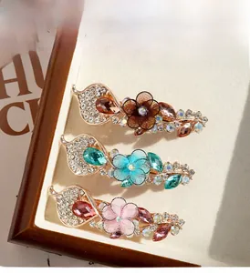 Gros plan de pinces à cheveux à fleurs avec strass et pétales en tissu sur fond neutre