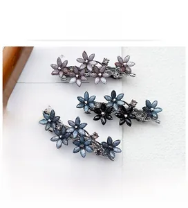 Detail von Vintage-Blumenhaarklammern mit lila und blauen Kristallen auf Metallbasis