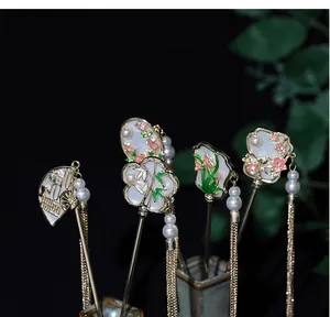 Detailed close-up of golden Chinese hairpins with fans, flower motifs and silk tassels