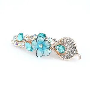 Barrette à cheveux florale avec strass bleus et fleur en résille sur base dorée