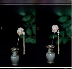 Detail of fan-shaped hairpins with tassels, pearls and floral motifs in oriental style