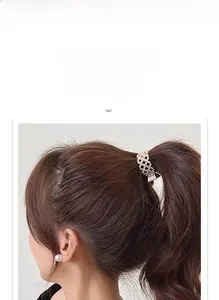 Detail of a sparkling gold metal hair claw with rhinestones for a high ponytail style