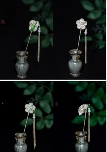 Detail of four Chinese hair sticks featuring orchid, plum, bamboo and fan motifs