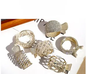 Detailed view of gold alloy hair claws with rhinestones and pearls in various designs