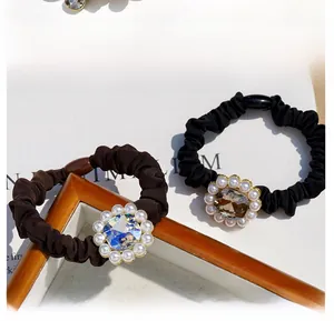 Macro detail of silk scrunchies with square crystals and pearl borders in dark brown