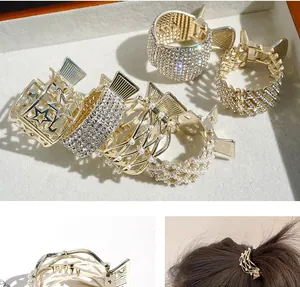 Macro shot of assorted golden metal hair claws with rhinestones and pearls on tray