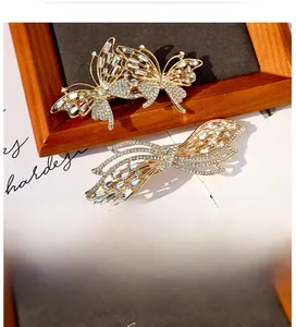 Close-up of golden butterfly hair clips with sparkling rhinestones on vintage paper