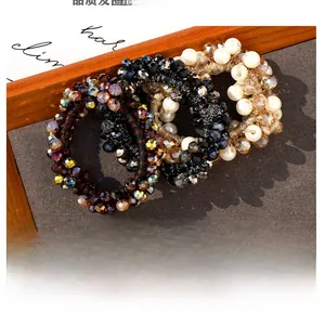 Dettaglio di un set di elastici per capelli con perle eleganti in marrone e nero