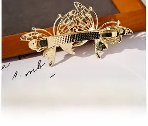 Close-up of the metal spring clip mechanism on a golden butterfly luxury hair accessory