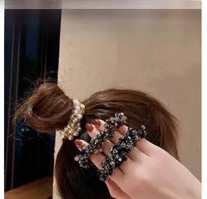 Dettaglio di elastici per capelli con perle e perline sfaccettate su uno chignon