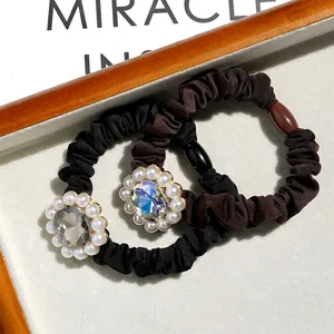Elegant satin hair scrunchies set with pearl and crystal flower detail in black and brown