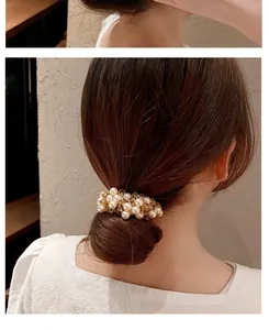 Elegante elastico per capelli con perle su uno chignon castano per uno stile chic