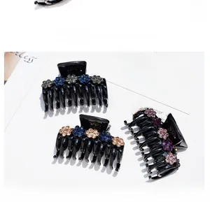 Detail of black acrylic hair claws with elegant rhinestone flowers on magazine background