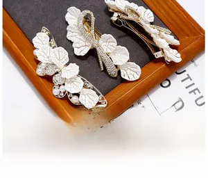 Detailed set of three rose gold leaf hair clips with white pearls and sparkling rhinestones