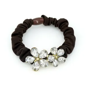 Elegant deep brown elastic hair tie featuring crystal flower charms and gold accents
