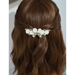 Elegant white leaf spring clip with pearls and rhinestones on brunette wavy hair