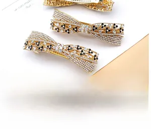 Detailed close-up of gold alloy bow hair clips with rhinestones and floral accents