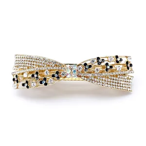Golden bow hair clip with sparkling rhinestones and delicate black white enamel flowers