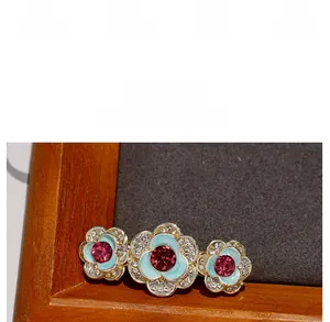 Detailed view of vintage rose hair clip with blue enamel petals and pink crystals