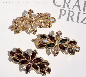 Close-up of floral crystal hair clips in champagne, amber, and purple with diamond accents
