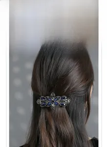 Detail of elegant floral spring clip featuring dark blue and grey crystals on metal base