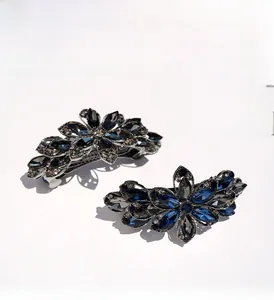 Detail of floral hair clips with dark blue marquise crystals on silver metal base