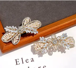 Detail view of luxury gold alloy hair clips with white pearls and sparkling zircons