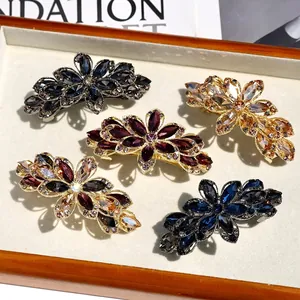 Elegant floral crystal hair clips with sparkling rhinestones in a luxury wooden tray