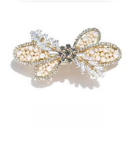 Close-up of butterfly hair clip with white pearls and sparkling zircon crystals
