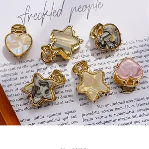 Macro shot of assorted acetate heart and star mini claw clips with marble textures