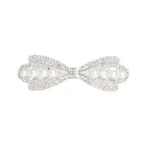 Eleganter silberner Haarschmuck als Schleife mit Strasssteinen und weißen Perlen auf Weiß