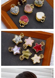 Detail of mini acetate hair clips in heart and star shapes with elegant gold-plated bases