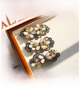 Dettaglio di fermagli per capelli vintage a fiore con cristalli champagne e pietre opale
