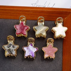 Set of six colorful star-shaped acetate hair claws with gold metal frames and patterns