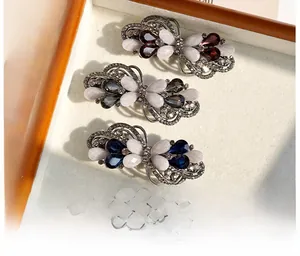 Dettaglio di tre fermagli per capelli vintage con strass colorati e cristalli eleganti