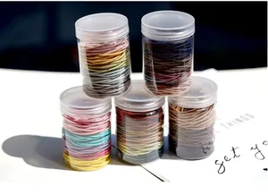 Macro detail of five clear cylinders filled with colorful high-elastic hair ties
