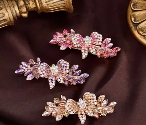 Macro shot of sparkling crystal flower hair clips on dark velvet with vintage gold detail