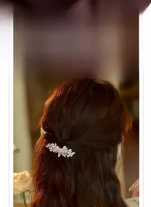 Detail of elegant bow spring hair clip with sparkling white and champagne crystals