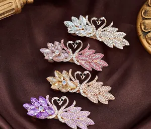 Macro shot of swan hair clips with crystal inlay on golden spring metal base