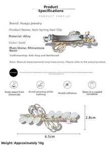 Détail d'une barrette à ressort dorée avec larme en résine et strass de 6,5 cm