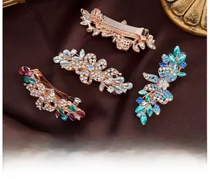 Detailed macro view of four crystal floral hair clips with rhinestones on satin fabric