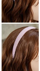Detailansicht eines rosa karierten Stoff-Haarreifens auf einem Modell mit braunem Haar